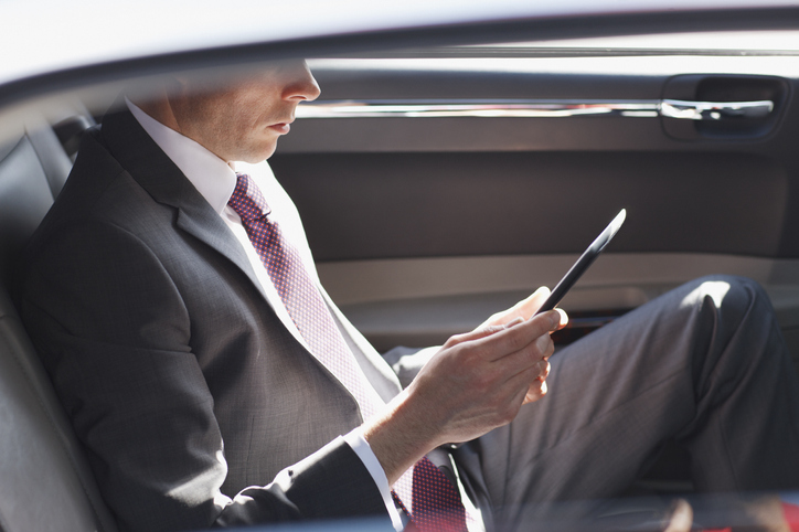 Politician reading in backseat of car